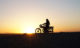 Woman riding motorcycle at Sunset