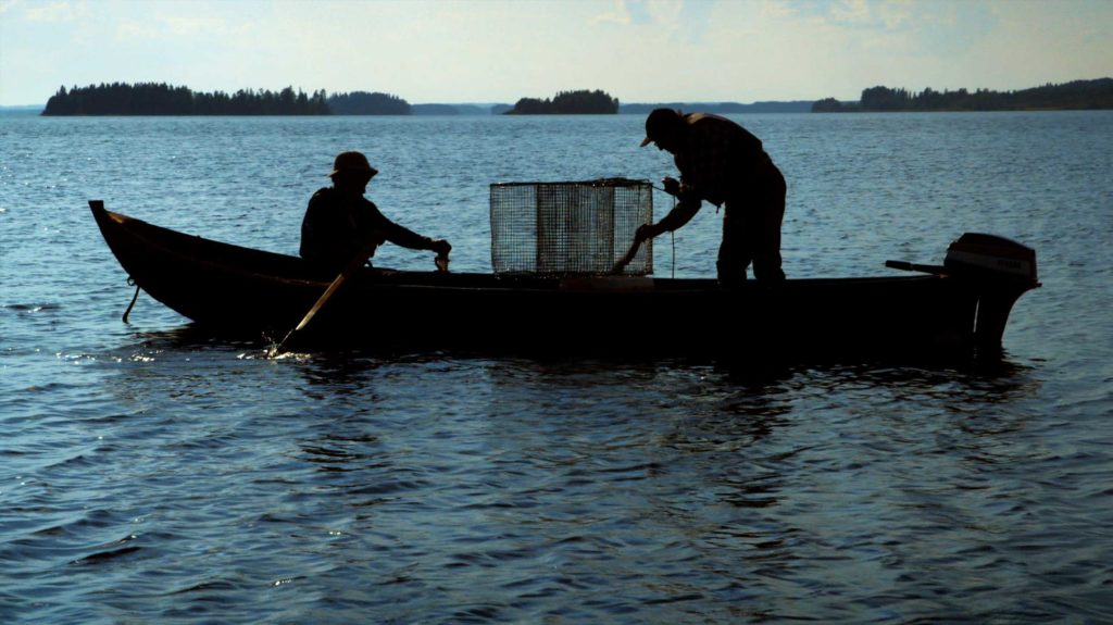 Two men on small fishing boat sillouette