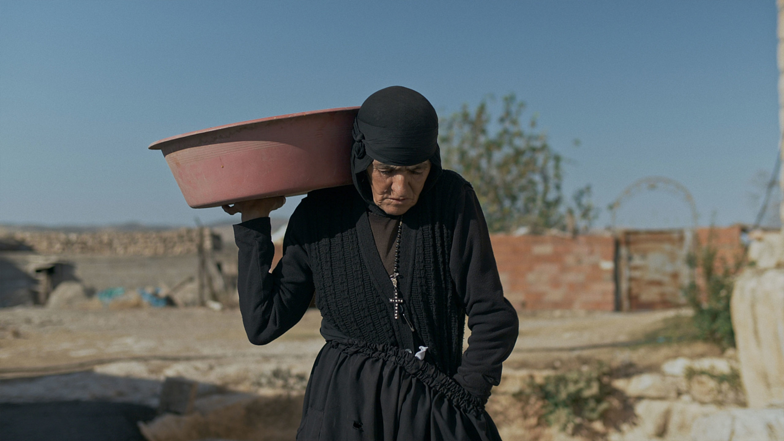 Nun Dayrayto carrying a pot on her shoulder