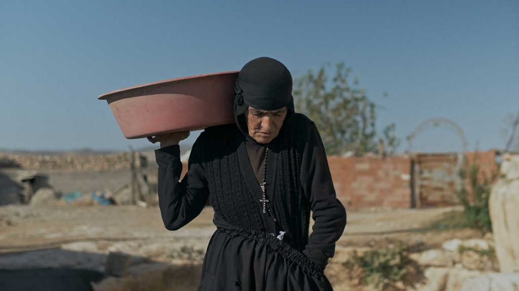 Nun Dayrayto carries a large pot over her shoulder