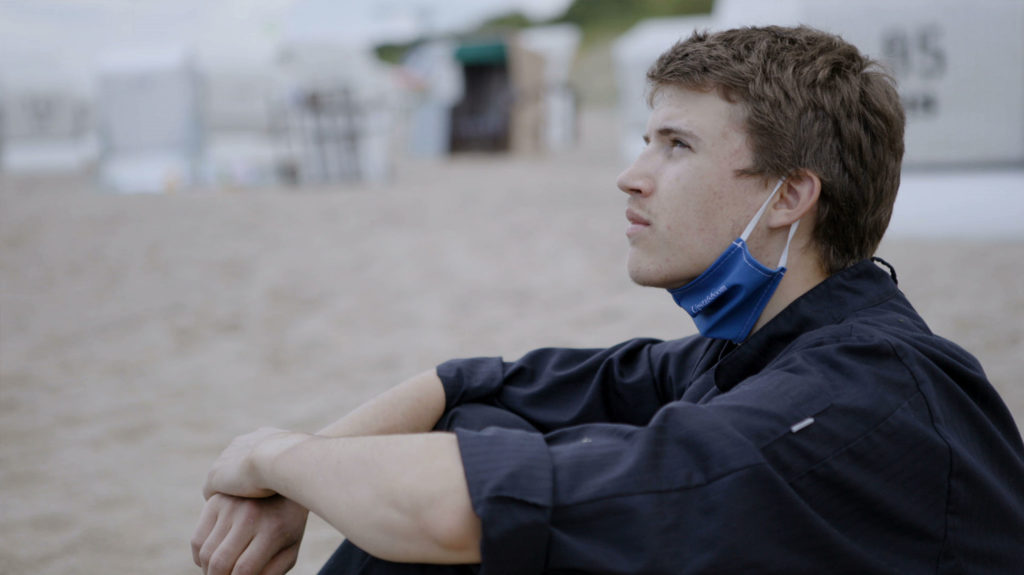 Young Man Sitting on Beach Baltic Sea