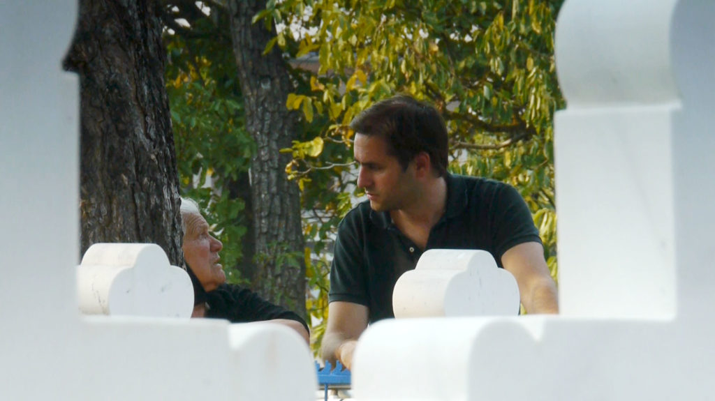 Man with older Serbian woman at cemetary