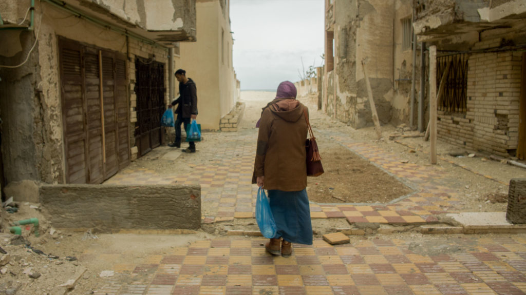 Woman walking through run-down Egyptian town